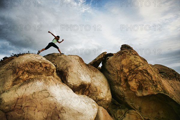 Vietnamese woman running on rocky hilltop