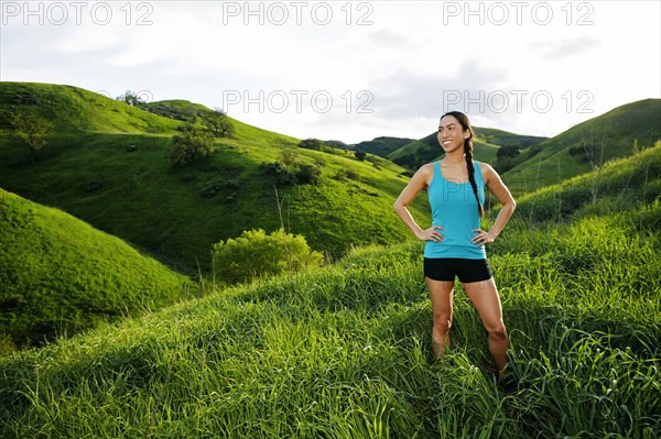 Mixed race athlete standing on rural hillside