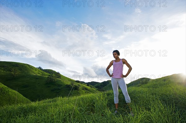 Black athlete standing on rural hillside