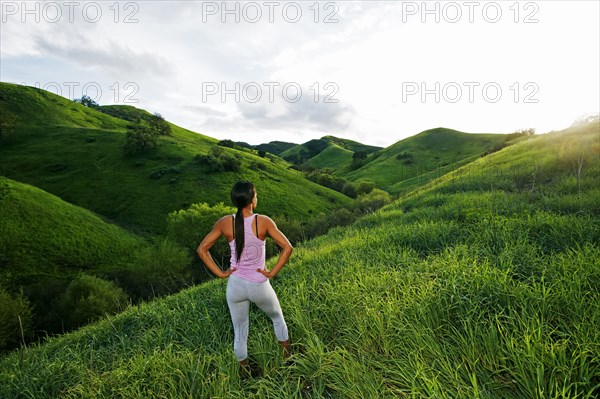 Black athlete admiring scenic view from rural hillside
