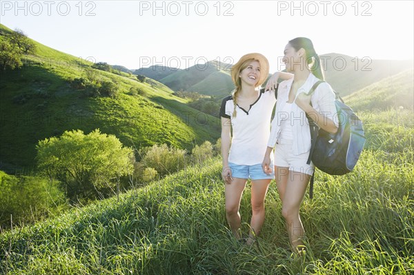 Women talking on grassy hillside