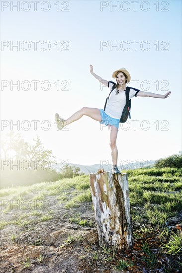 Caucasian woman balancing on dilapidated stump