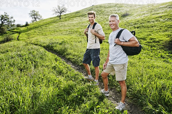 Caucasian father and son walking on dirt path