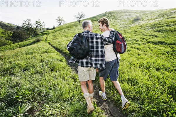 Caucasian father and son walking on dirt path