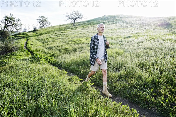 Older Caucasian man walking on dirt path