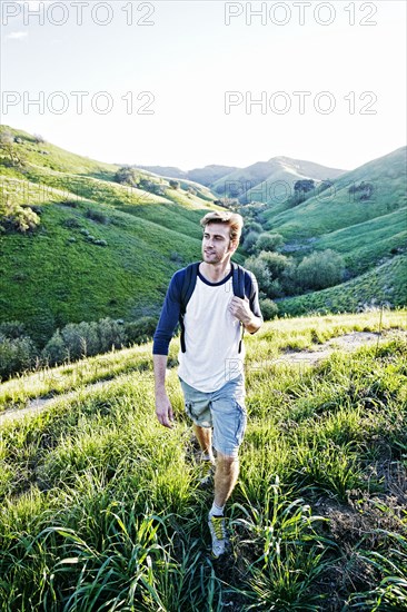 Caucasian man walking on rural hillside