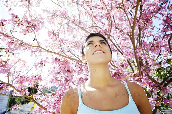 Hispanic woman standing under flowering tree