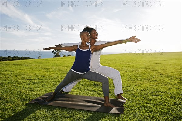 Women practicing yoga in park