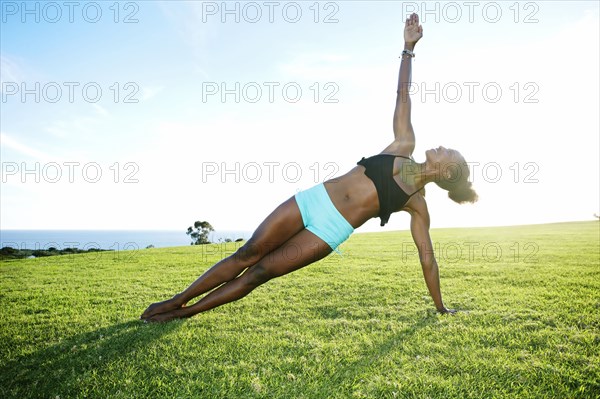 African American woman practicing yoga in park