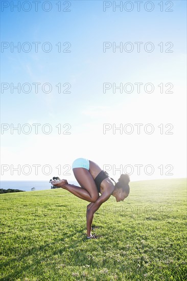 African American woman practicing yoga in park