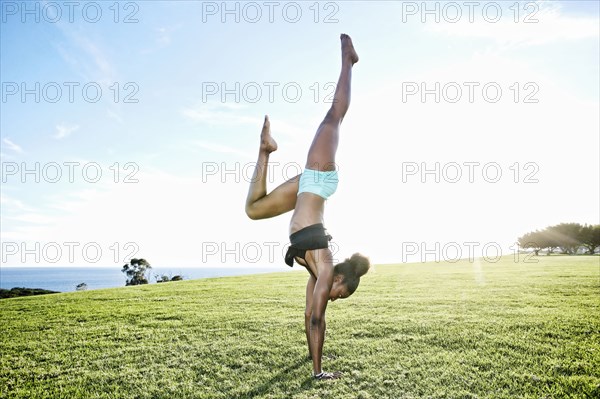 African American woman practicing yoga in park