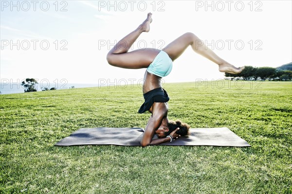 African American woman practicing yoga in park