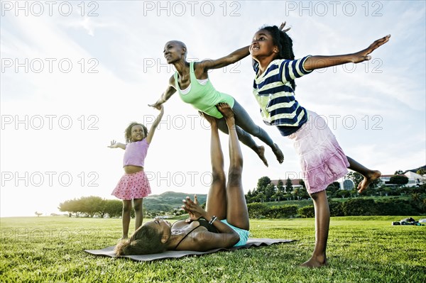 Family practicing acro yoga in park