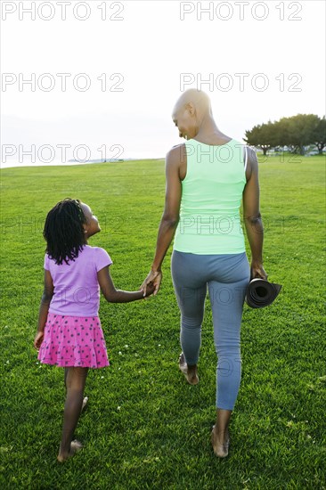Mother and daughter holding hands in park