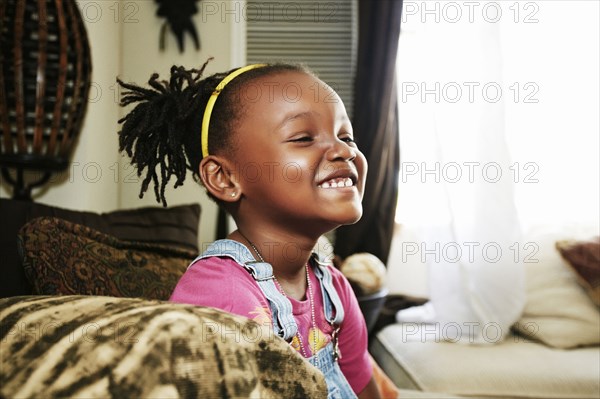 Black girl smiling on sofa