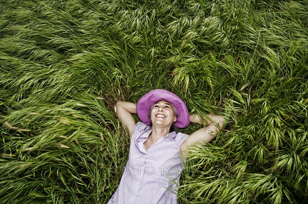 Caucasian woman laying in tall grass