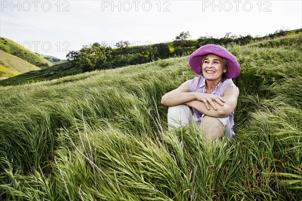 Caucasian woman sitting in tall grass