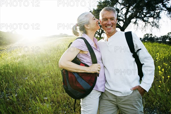 Caucasian couple kissing in tall grass