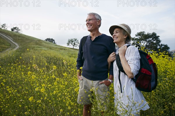 Caucasian couple standing in tall grass