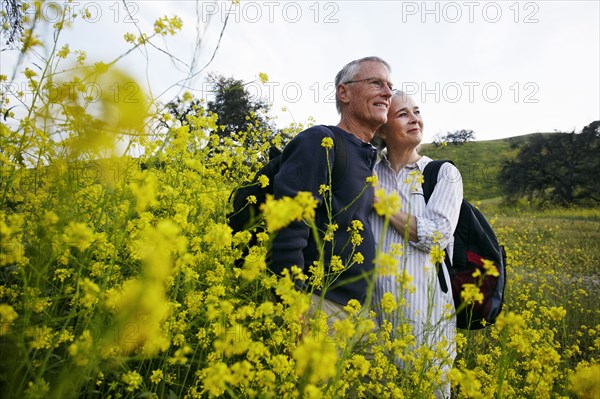 Caucasian couple hugging in tall grass
