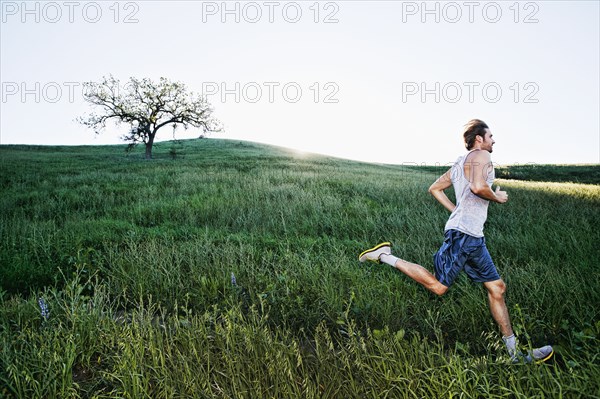 Caucasian athlete running on rural trail