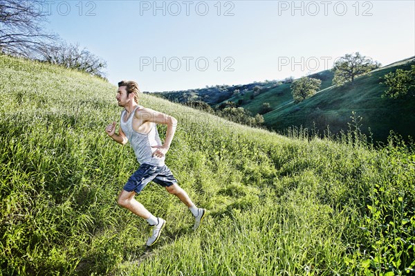 Caucasian athlete running on rural trail