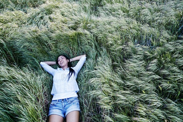 Mixed race woman laying in grass
