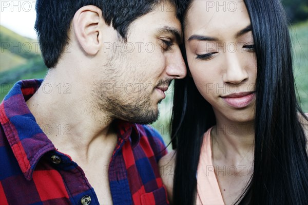 Close up of couple nuzzling outdoors