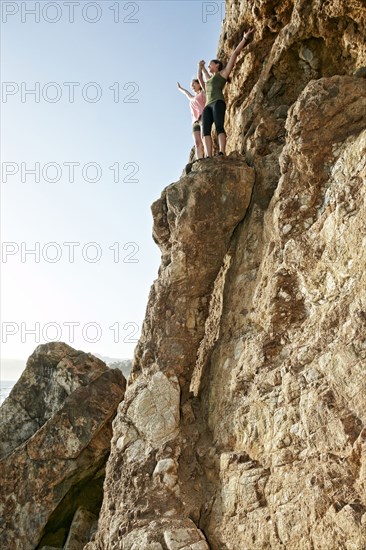 Climbers cheering on rock formation