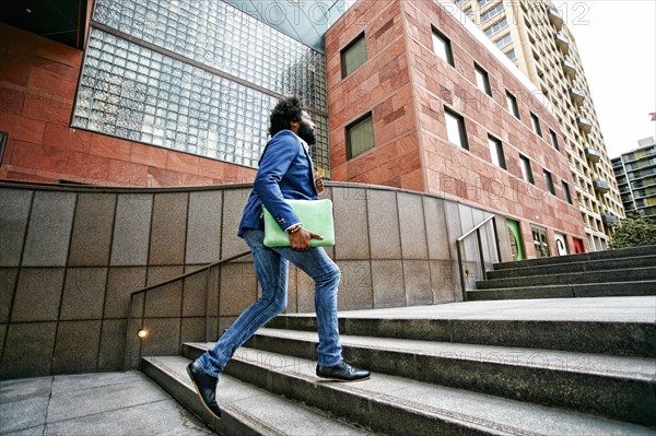 Mixed race businessman walking on steps