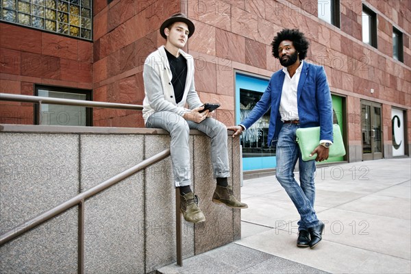 Businessmen at banister on walkway