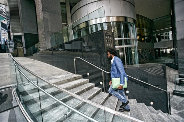 Mixed race businessman carrying digital tablet