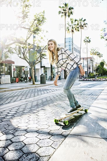 Caucasian woman riding skateboard