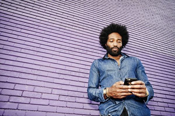 Mixed race man using cell phone outdoors