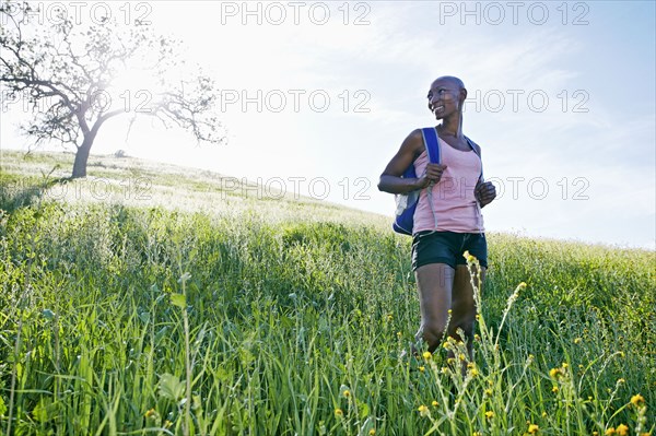 Black woman walking on rural hillside