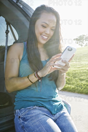 Asian woman using cell phone outdoors