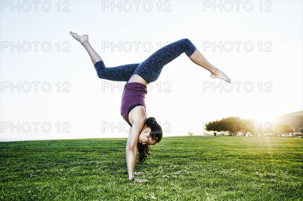 Asian woman practicing yoga outdoors