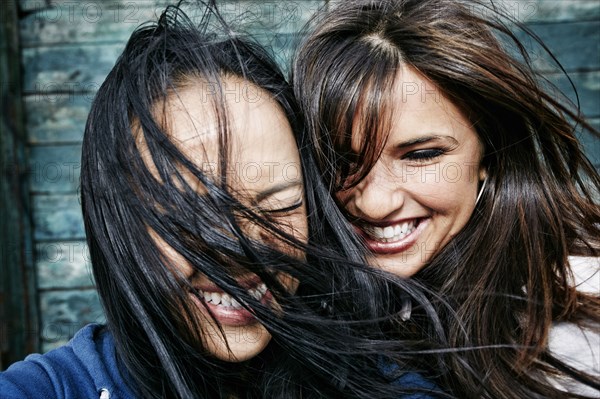 Women laughing with hair blowing in wind