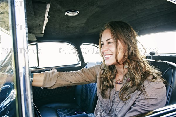 Mixed race woman driving vintage car