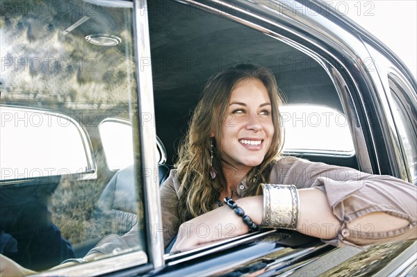 Mixed race woman driving vintage car