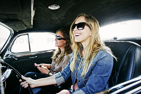 Women driving vintage car