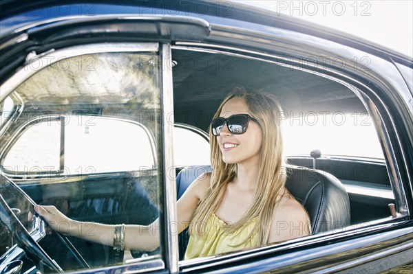 Caucasian woman driving vintage car