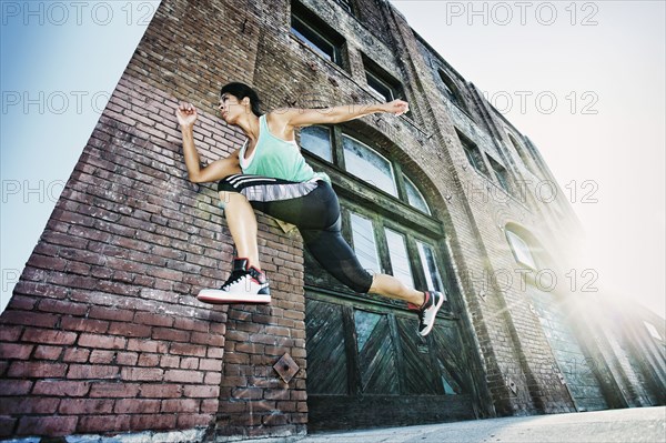 Mixed race woman jogging on sidewalk