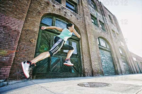 Mixed race woman jogging on sidewalk