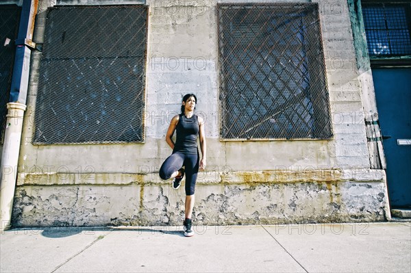 Mixed race woman leaning on wall