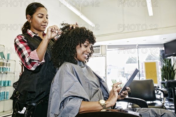 Hairstylist cutting hair of customer in salon