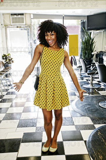 Mixed race hairstylist smiling in salon