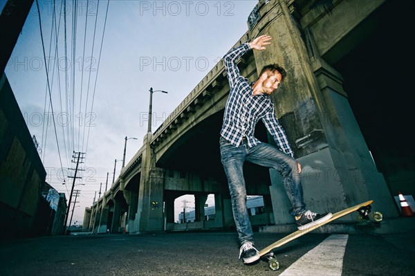 Caucasian man riding skateboard outdoors