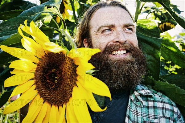 Caucasian man holding sunflower in garden