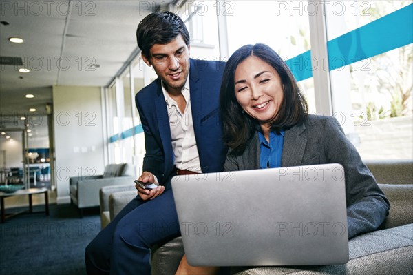 Business people using laptop in office